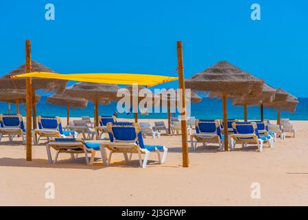 Sonnenliegen am Praia da Rocha in Portugal. Stockfoto