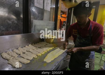 Bogor, Indonesien. 07. April 2022. Am 7. April 2022 arbeitet ein Bäcker an einer maryam-Brotproduktion in Bogor, West-Java, Indonesien. Maryam Brot oder Cane Brot sehr beliebtes Street Food in Südostasien. Ähnlich verhält es sich mit weißem Fladenbrot, aber mit mehr Schichten und Knusprigkeit, die während des muslimischen Fastenmonats Ramadan sehr gefragt sind. (Foto von Andi M Ridwan/INA Photo Agency/Sipa USA) Quelle: SIPA USA/Alamy Live News Stockfoto
