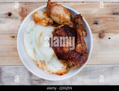 Traditionelles südafrikanisches Pap and Quarter Chicken, Maismehl mit gebratenem Huhn Stockfoto