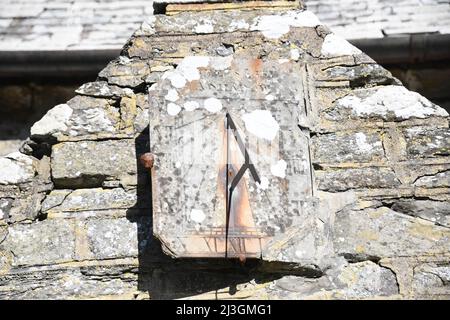 Die Sonnenuhr über dem normannischen Eingang in die Kirche St. Morwenna und St. Johannes der Täufer, die Pfarrkirche von Morwenstow, North Cornwall. Stockfoto