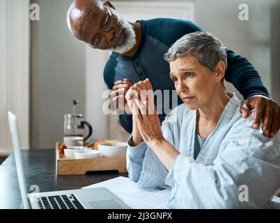 Ich weiß, dass es stressig ist, aber ich bin hier für Sie. Ein Foto eines älteren Ehepaares stresste aus, ihr Budget zu Hause zu erledigen. Stockfoto