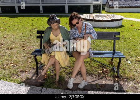 USA, Florida, Key West, die Keys, Touristen auf einer Bank im Garten des Key West Lighthouse Stockfoto
