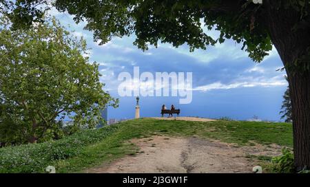 BELGRAD, SERBIEN - 19. JULI 2018: Zwei junge Frauen sitzen auf der Bank vor dem "Gewinner"-Denkmal im Kalemegdan Park Stockfoto