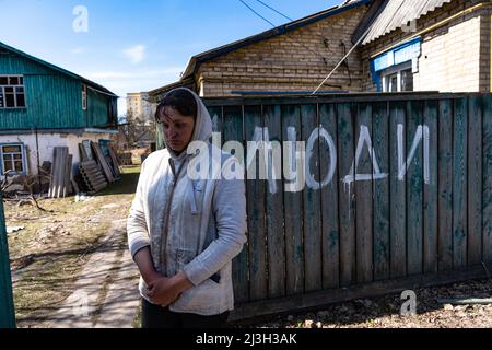 BUCHA, UKRAINE - 7. APRIL 2022 - die ortsansässige Tetiana bleibt nach der Befreiung der Stadt von den russischen Eindringlingen Bucha und Kyiv Re vor ihrem Haus Stockfoto