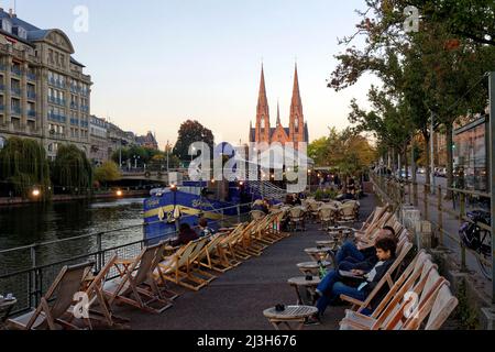 Frankreich, Bas-Rhin, Straßburg, Altstadt, die von der UNESCO zum Weltkulturerbe erklärt wurde, Cafés Boote auf dem Quai des Batelers am Ufer der Ill und Saint-Paul Kirche im Hintergrund Frankreich, Bas-Rhin (67), Straßburg, vieille ville classée au Patrimoine Mondial de l'UNESCO, Bistrots péniches le long du quai des Pêcheurs au Bord de l'ill avec église Saint-Paul en arrière Plan Stockfoto