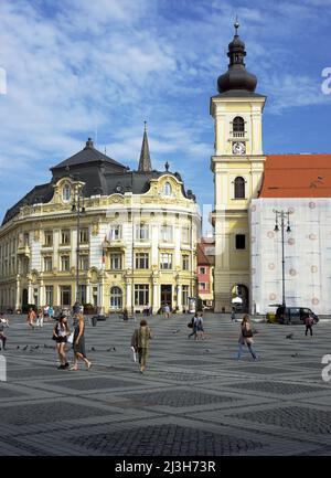 SIBIU, RUMÄNIEN - 31. JULI 2018: Rathaus und Glockenturm der römisch-katholischen Kirche der Heiligen Dreifaltigkeit auf dem zentralen Platz von Piata Mare Stockfoto