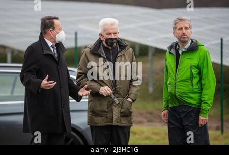 08. April 2022, Baden-Württemberg, Tübingen: Klaus Tappeser (l, CDU), Präsident des Regierungsbezirks Tübingen, blickt zusammen mit Winfried Kretschmann (M, Bündnis 90/die Grünen), Ministerpräsident von Baden-Württemberg, und Boris Palmer (r, Bündnis 90/die Grünen), Oberbürgermeister von Tübingen, auf den Solarpark Lustnauer Ohren. Foto: Christoph Schmidt/dpa Stockfoto