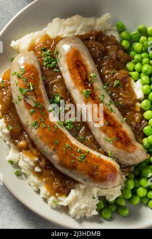 Hausgemachte britische Bangers und Maische mit Zwiebelsoße Stockfoto