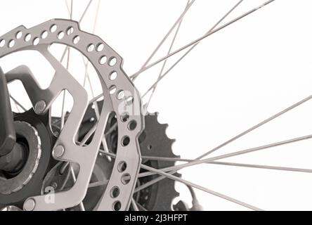 Nahaufnahme des Fahrrads mit Bremsscheibe, Kettenrad und Speichen in schwarz-weiß auf weißem Hintergrund Stockfoto