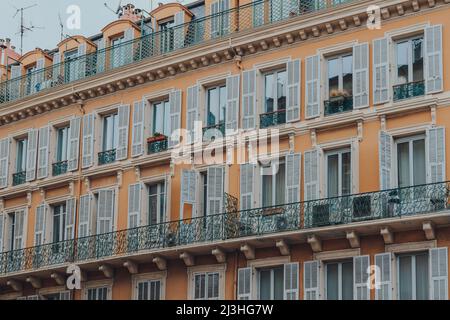 Nizza, Frankreich - 10. März 2022: Blick aus der Nähe auf ein traditionelles Wohnhaus in Nizza, einem berühmten Touristenziel an der französischen Riviera. Stockfoto