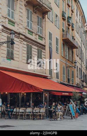Nizza, Frankreich - 10. März 2022: Menschen sitzen an den Tischen im Freien der Brasserie Tobacco Lou Pastrouil in der Altstadt von Nizza, einem berühmten touristischen Desti Stockfoto