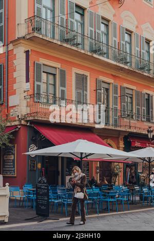 Nizza, Frankreich - 10. März 2022: Außenansicht von Boulangerie Jeannot in Nizza, einem berühmten Touristenziel an der französischen Riviera, kommt die Frau vorbei. Stockfoto