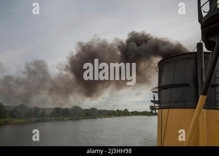 Aus einem Schiffskamin kommt dunkler Rauch Stockfoto