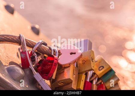 Love Locks auf einer Brücke auf rosa Hintergrund Stockfoto