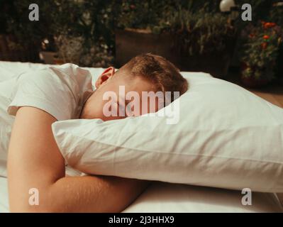 Mann schläft auf dem Bett im Schlafzimmer zu Hause blonde Korn-Effekt Stockfoto