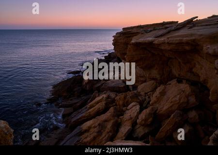 Sonnenuntergang über der Felsküste am Atlantik zwischen Burgau und Luz westlich von Lagos, Algarve, Barlavento, Westalgarve, Felsenalgarve, Bezirk Faro, Portugal, Europa Stockfoto