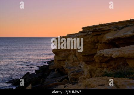 Sonnenuntergang über der Felsküste am Atlantik zwischen Burgau und Luz westlich von Lagos, Algarve, Barlavento, Westalgarve, Felsenalgarve, Bezirk Faro, Portugal, Europa Stockfoto