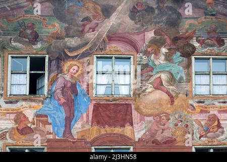 In einer Szene der Mariä Verkündigung bringt der Engel Maria eine weiße Lilie, biblische Szene, Lüftlmalerei an die Hausfassade in Mittenwald, Oberbayern Stockfoto