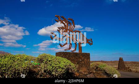 Kanarische Inseln, Lanzarote, Vulkaninsel, Jameos del Agua, entworfen von Cesar Manrique, einzigartiger vulkanischer Tunnel und Höhlen mit unterirdischer Konzerthalle, Restaurant und Salzsee, Wahrzeichen des Jameso del Agua draußen am Höhleneingang und Parkplatz, himmeldunkelblau und klar, wenige grau-weiße Wolken Stockfoto