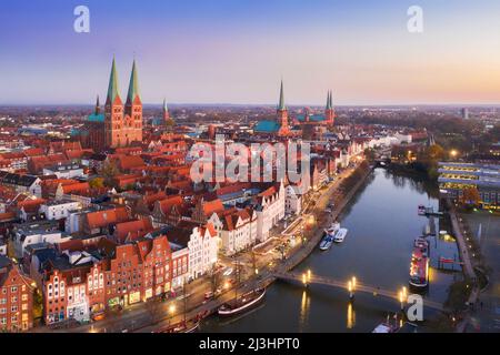 Luftaufnahme über die Trave und Kirchtürme in der Altstadt der Hansestadt Lübeck bei Sonnenuntergang, Schleswig-Holstein, Deutschland Stockfoto