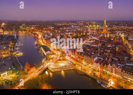 Luftaufnahme über die Trave, den Hafen und die Jakobskirche in der Altstadt der Hansestadt Lübeck bei Sonnenuntergang, Schleswig-Holstein, Deutschland Stockfoto