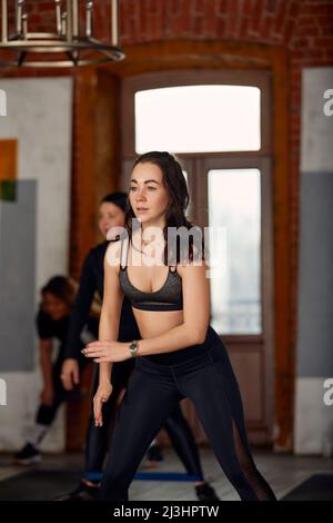 Eine große, vielfältige Gruppe von Menschen, die Aerobic-Übungen in einer Klasse in einem Fitnessstudio in einem Gesundheits- und Fitnesskonzept machen. Stockfoto