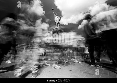 Liberty Island, New York City, NY, USA, Langzeitbelichtung der Freiheitsstatue und Touristen, die verschwommen und in Bewegung sind Stockfoto