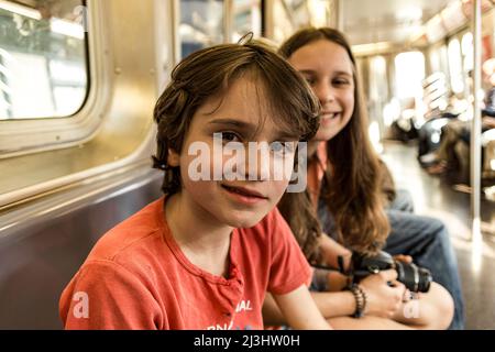 Myrtle AV, New York City, NY, USA, 14 Jahre altes kaukasisches Teenager-Mädchen und 12 Jahre altes kaukasisches Teenager-Mädchen – beide mit braunen Haaren und sommerlichem Styling in einer U-Bahn Stockfoto