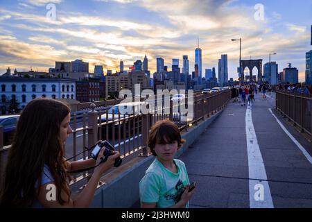 ANCHORAGE PLAZA, New York City, NY, USA, zwei Kinder auf der Brooklyn Bridge über dem East River 14 Jahre altes kaukasisches Teenager-Mädchen und 12 Jahre altes kaukasisches Teenager-Mädchen - beide mit braunen Haaren und Sommer-Styling auf der Brooklyn Bridge am Abend Stockfoto