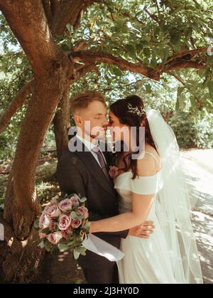 Glückliches Brautpaar zu Fuß in einem botanischen Park Korn-Effekt authentisch Stockfoto