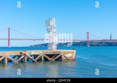Statue mit Hintergrund, bestehend aus Brücke vom 25.. April und Nationalheiligtum von Cristo Rei in Lissabon, Portugal. Stockfoto