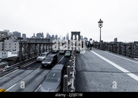 FRONT ST/YORK ST, New York City, NY, USA, Long Exposure mit Autos von der Brooklyn Bridge über den East River und der Skyline von Manhattan im Nebel Stockfoto