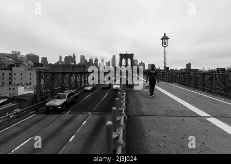 FRONT ST/YORK ST, New York City, NY, USA, Long Exposure mit Autos von der Brooklyn Bridge über den East River und der Skyline von Manhattan im Nebel Stockfoto