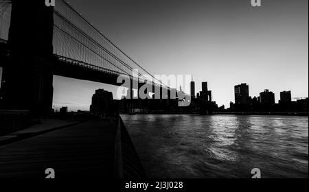 DUMBO/Fulton Ferry, New York City, NY, USA, die Skyline von New York/Manhattan und die Brooklyn Bridge über den East River kurz nach Sonnenuntergang Stockfoto