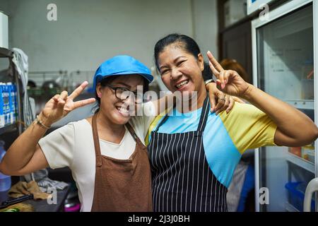Küchenfreunde. Portrait von zwei glücklichen Köchen, die in der Küche posieren. Stockfoto