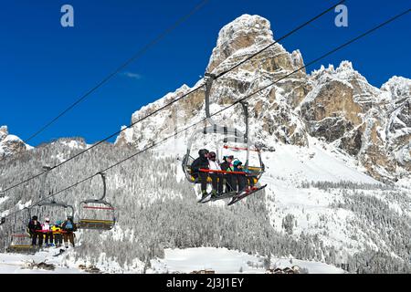 Skifahrer auf dem Sessellift im Skigebiet La Villa, Stern, hinter dem Sassongher, Alta Badia, Dolomiten, Südtirol, Italien Stockfoto