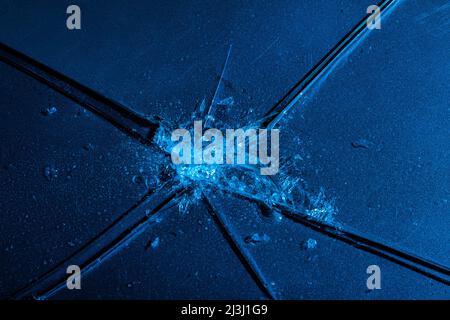 Nahaufnahme der Fototextur von blauem gebrochenem und rissem Glas auf schwarzem Hintergrund. Stockfoto