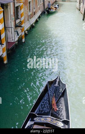 Blick auf die Spitze einer venezianischen Gondel auf einem schmalen Kanal in Venedig, Italien Stockfoto