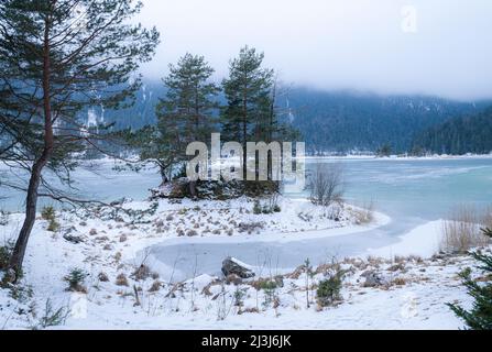 Blick auf den gefrorenen Eibsee mit einer kleinen Halbinsel, Grainau bei Garmisch-Partenkirchen, Bayern, Oberbayern, Deutschland, Europa Stockfoto