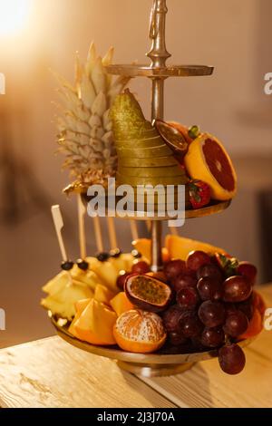 Rohe Früchte Beeren Platter, Mango, Orangen, Kiwi, Erdbeeren, Blaubeeren grapefruit Trauben, Bananen, Äpfel auf dem weißen Teller, auf dem Weg von weißen Tabl Stockfoto