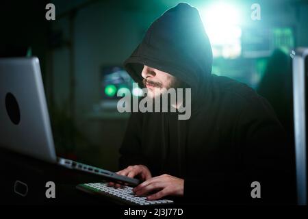 Hacker-Mann macht einen Computerangriff beginnend mit der Eingabe auf Laptop-Tastatur und brechen Passwort. Männer, die in Sicherheitssysteme hacken Stockfoto