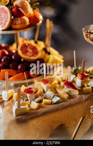Käseplatte serviert mit Nüssen und Beeren, ein Gourmet-Käse mit Nüssen und Beeren auf einem runden Brett, reich an Geschmack und Kombinationsfähigkeit Stockfoto