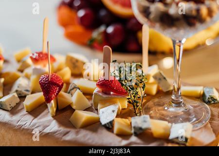 Italienische Bruschetta mit Frischkäse, Erdbeere, Rucola und Balsamico-Essigsauce mit Honig. Vorspeise mit Chiabatta-Brot und Erdbeere auf Holz Stockfoto