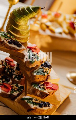 Bruschetta mit verschiedenen Füllungen auf dem Teller. Grauer Betonhintergrund. Catering-Service – Fotografie. Stockfoto