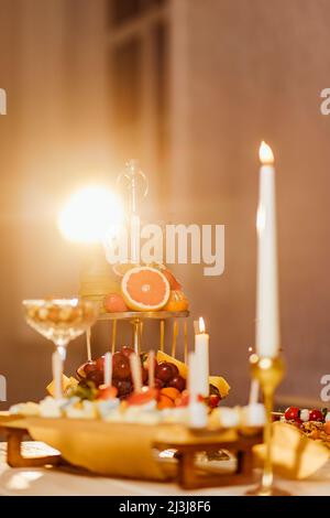 Luxuriöser romantischer Dinner-Tisch bei Kerzenschein für Paare im Restaurant mit Meerblick am Valentinstag mit Champaign Weingläsern und wunderschönem Essen d Stockfoto