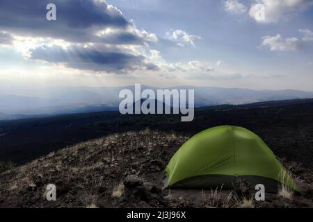 Dramatischer Himmel auf vulkanischer Landschaft vom Zelt auf altem seitlichen Krater über Baumgrenze im Ätna Park, Sizilien Stockfoto