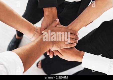 Einheit gewinnt immer. Nahaufnahme einer Gruppe von nicht erkennbaren Geschäftsleuten, die sich in einer Gruppe zusammengeschlossen haben. Stockfoto