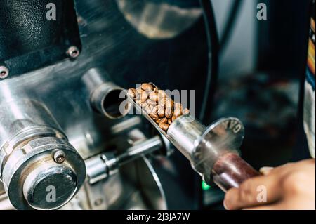 Kaffeeröstermaschine beim Kaffeerösterprozess. Kaffeebohnen mischen Stockfoto