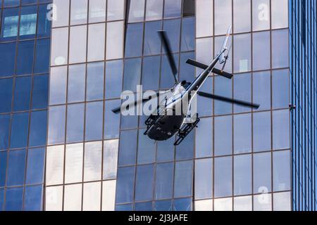 Wien, Helikopter vor dem Wolkenkratzer DC Tower 1, Spiegelglasfassade, dunkle Fenster, Airbus Helicopters AS355 Ecureuil, für Dreharbeiten zum Netflix-Film 'Tyler Rake ñ Extraction' mit dem Schauspieler Chris Hemsworth im Bezirk 22. Donaustadt, Österreich Stockfoto