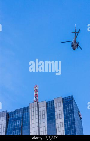 Wien, Helikopter vor dem Wolkenkratzer DC Tower 1, Spiegelglasfassade, dunkle Fenster, Airbus Helicopters AS355 Ecureuil, für Dreharbeiten zum Netflix-Film 'Tyler Rake ñ Extraction' mit dem Schauspieler Chris Hemsworth im Bezirk 22. Donaustadt, Österreich Stockfoto